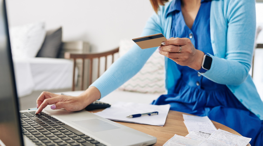 a women using her laptop to enter payment information from a credit card