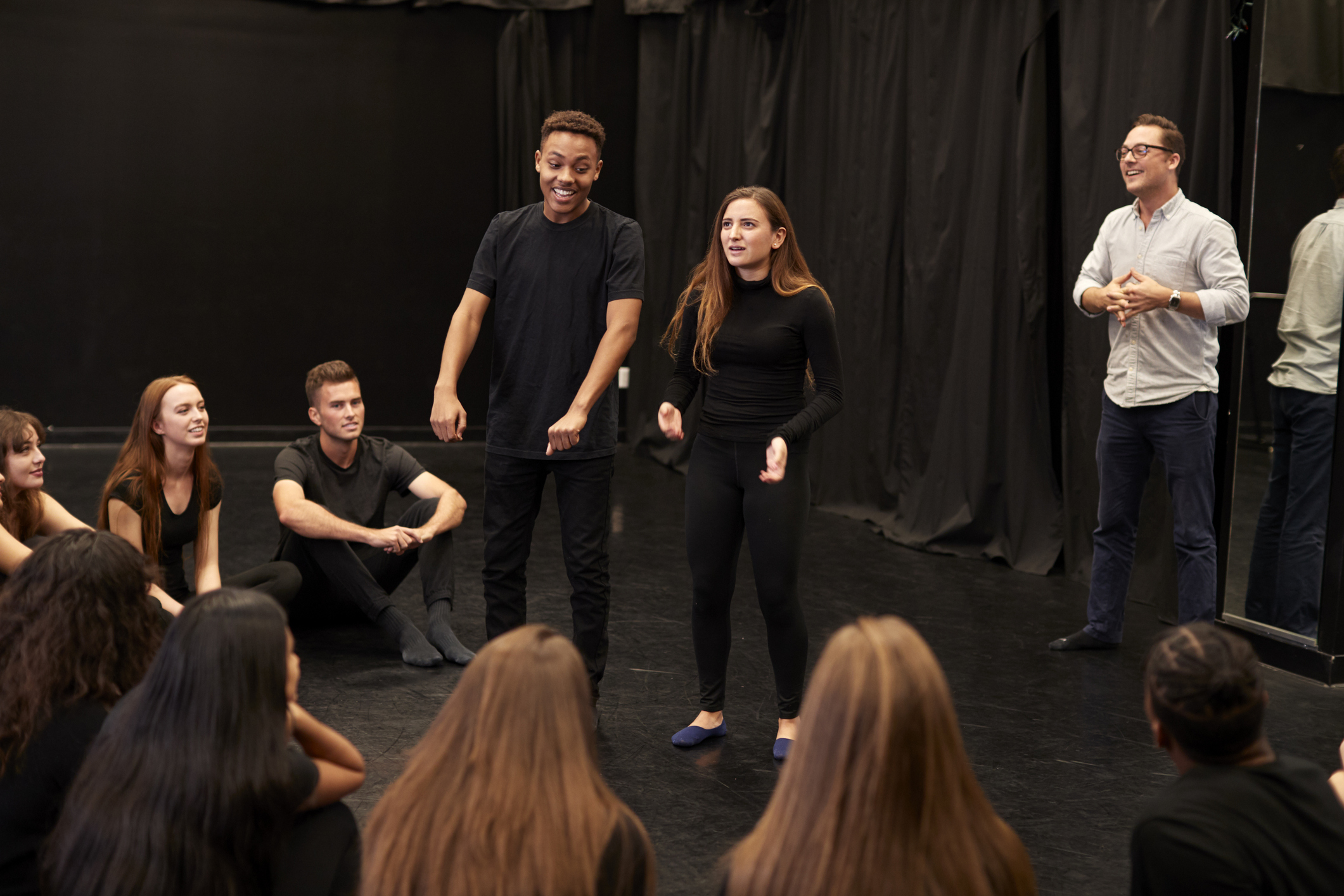 Teacher With Male And Female Drama Students In Studio Improvisation Class