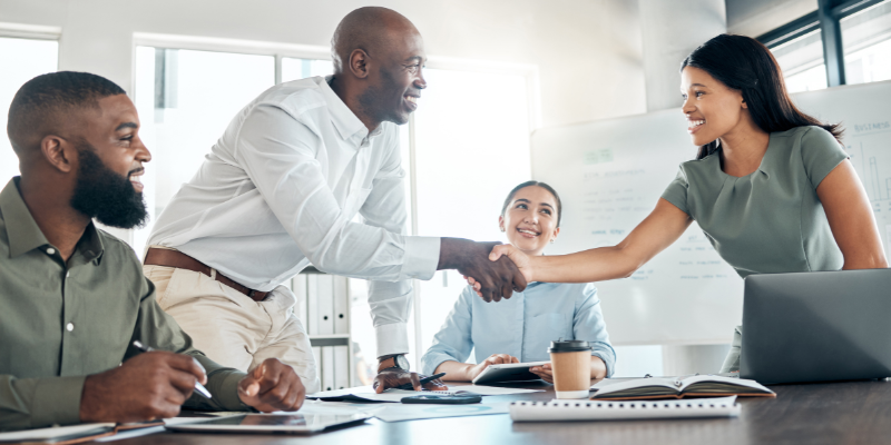 man shaking hands with a woman at a corporate meeting